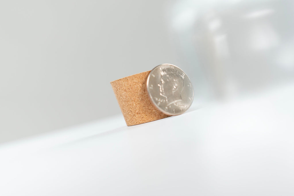 Coin standing against a small cork insert for Coin Pitcher