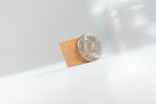Coin standing against a small cork insert for Coin Pitcher