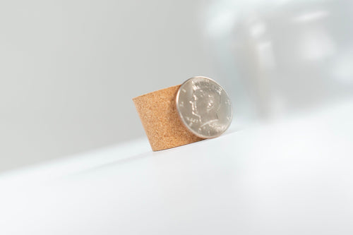 Coin standing against a small cork insert for Coin Pitcher