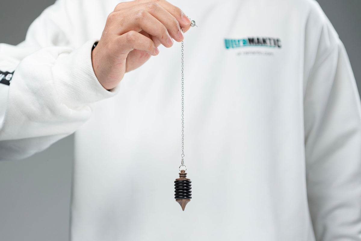 Performer displaying the Impulse Pro pendulum by its chain