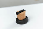 Coin Pitcher cork device displayed in a black stand