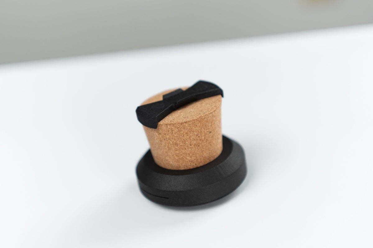 Coin Pitcher cork device displayed in a black stand