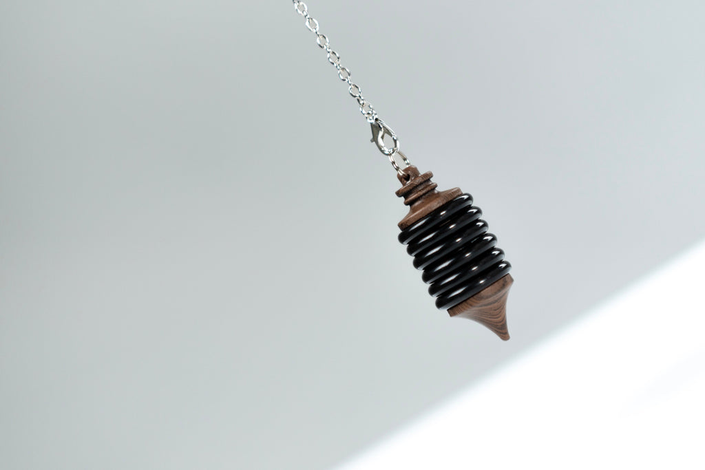 Close-up of the black Impulse Pro pendulum hanging from its chain