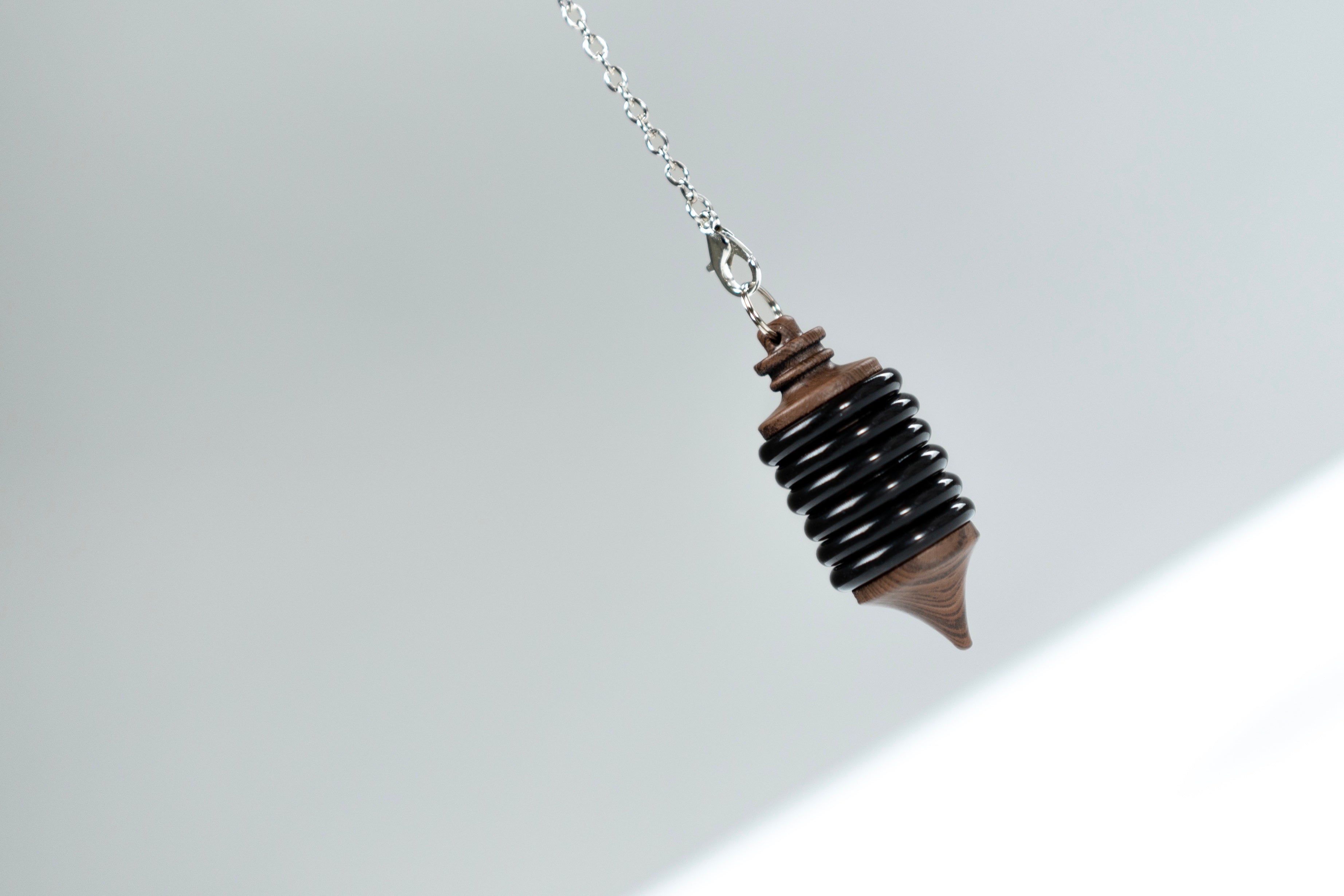 Close-up of the black Impulse Pro pendulum hanging from its chain
